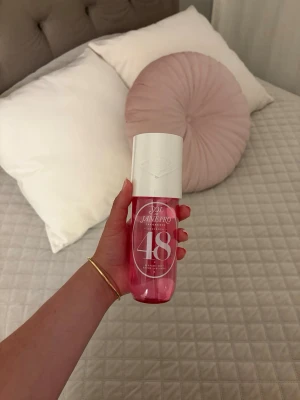 Sol de Janeiro 48 Body Fragrance Mist - Fräsch body mist från Sol de Janeiro i en snygg rosa flaska med vit kork. Doften är tropisk och söt, perfekt för dig som vill ha en fräsch och ungdomlig parfym. Flaskan är smidig att ta med i väskan och har en modern design.