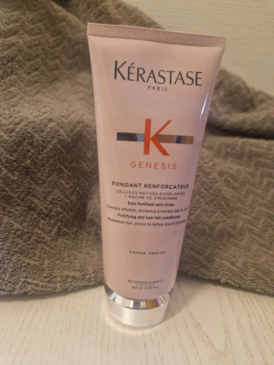 Kérastase Genesis balsam 200ml - Kérastase Genesis Fondant Renforçateur är ett stärkande balsam för svagt hår som lätt faller av. Kommer i en ljusrosa tub med silverdetaljer och röd logga. Innehåller edelweiss och ingefärsrot för att motverka håravfall och stärka håret.