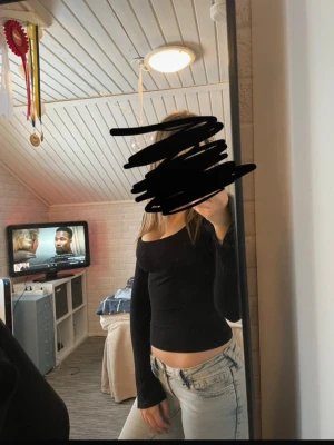 Svart långärmad topp från Gina Tricot - En svart, tight långärmad topp från Gina Tricot med bred, rundad urringning och har en slits i ärmarna. Toppen är enkel och stilren, MEN den har ett litet hål vid ärmen som jag inte märkte va där när jag köpte den.