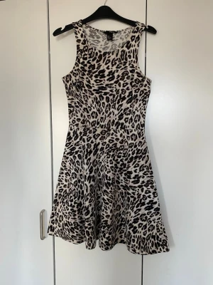 Leopardmönstrad klänning - Snygg leopardmönstrad kort klänning från H&M.  Klänningen är ärmlös med rund halsringning och har en lätt utställd kjol.