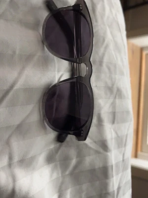 Transparenta solglasögon med lila glas - Snygga solglasögon med transparent båge och runda lila tonade glas. Klassisk och trendig modell som passar till många stilar. Perfekta för att ge din outfit en cool touch i solen.