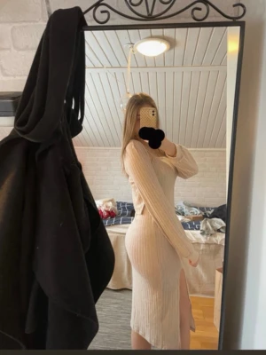 Beige ribbad långklänning med slits + bolero - Trendig beige långklänning i ribbat material med lång ärm och hög slits på sidan. Klänningen har en kroppsnära passform och är perfekt för dig som gillar en stilren look. Materialet känns mjukt och stretchigt, vilket gör den bekväm att bära hela dagen.