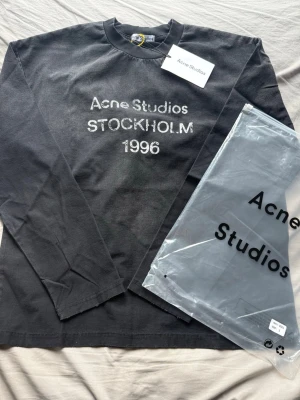 Svart Acne Studios Longsleeve Storlek S - Fin tröja som är oanvänd. Tröjan är efterlängtat så passa på att köpa. Acne tröja S: Mått📏: Längd: 69cm Bredd: 57cm Axelbredd: 57cm. Billig for a reason☺️Skriv vid minsta fundering👌