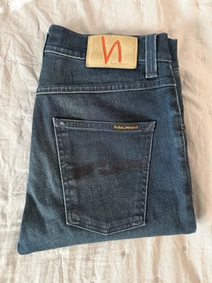 Nudie jeans mörkblå W28 L32 - Hej! Säljer nu ett par riktigt fina jeans från Nudie Jeans. Modell: Lean Dean  Storlek: W28/L32  Sitter snyggt och är enkla att matcha till allt, oavsett om du kör casual eller lite mer uppklätt.  Hör gärna av dig vid intresse 🙂  Mvh Elias