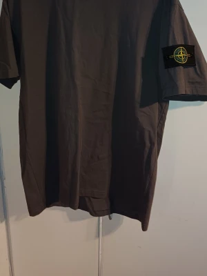 Mörkgrå t-shirt Stone Island - Säljer min stone island t-shirt pågrund av att den är för stor och det står att den är 4XL men den sitter som L-XL och har aldrig använts. Pris kan diskuteras!!
