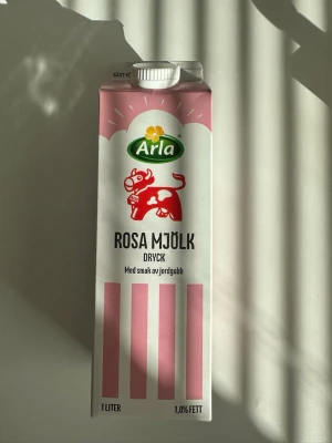 Arla Rosa Mjölk Jordgubb 1L - Säljer en 1 liters förpackning Arla Rosa Mjölk dryck med smak av jordgubb. Kartongen är vit med rosa detaljer och har en röd ko på framsidan. Drycken innehåller 1,0% fett och är perfekt för dig som gillar smaksatt mjölk.