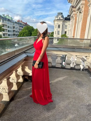 Röd balklänning med öppen rygg - Säljer min superfina röda långklänning som jag använde en gång på min studentbal. Väldigt smickrande modell med öppen rygg och fint fall i tyget ✨  Tvättad efter användning.  Jag är 164cm lång och min byst är runt 75–80cm.  Perfekt till bal, fest eller andra finare tillfällen 💃