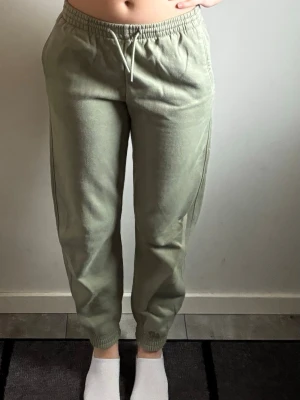 Ljusgröna mjukisbyxor med resår - Ljusgröna mjukisbyxor med resår i midjan och benslut. Byxorna har dragsko i midjan och sidofickor. De är tillverkade i ett mjukt och bekvämt material som passar perfekt för chill dagar. Snygg passform och enkel design.