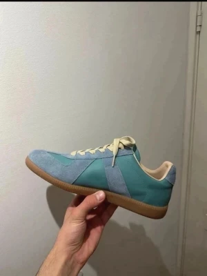 Ljusblå/turkos Maison Margiela GAT sneakers Storlek 44 - Säljer dessa Maison Margiela GAT sneakers i storlek 44. De är helt nya och aldrig använda.  Kartong ingår ej   Skick: oanvända Färg: Ljusblå/turkos med vita snören  Perfekt om du vill ha GAT-looken till ett billigt pris. Skriv gärna om du har några frågor , pris kan diskuteras och ni vet varför priset är så lågt 😊