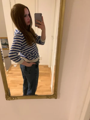 Randig blåvit kofta med knappar - Snygg kofta med blå och vita horisontella ränder och knäppning framtill. Tröjan har långa ärmar och ribbade muddar vid ärmslut och nederkant. Perfekt för en avslappnad och trendig look.