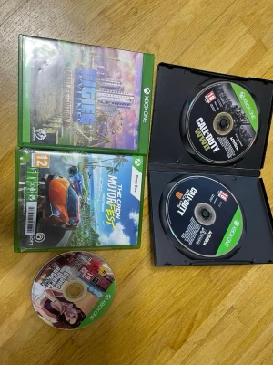 Xbox One spelpaket: 5 titlar - Säljer ett paket med fem Xbox One-spel: Cities Skylines, The Crew Motorfest, Call of Duty WWII, Call of Duty Black Ops III och Grand Theft Auto V. Spelen har färgglada omslag och är i standard plastfodral. Perfekt för dig som gillar action, racing och stadsbyggande.