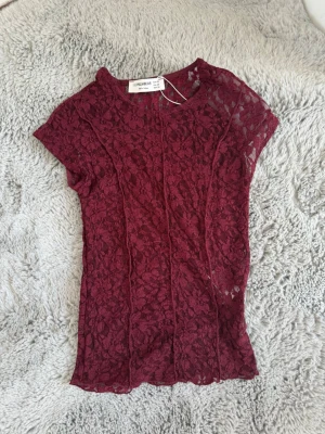 Vinröd spets tröja - En spetströja med tre ”ränder” som har en tajt passform. Vinröd och går att se igenom. Storlek xs från pull & bear. Med prislappen kvar❣️❣️
