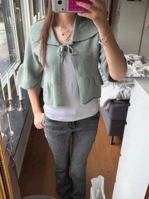 Ljusgrön kofta med volangärm❣️ - Supersöt ljusgrön kofta med trekvarts volangärmar och stor krage. Koftan har knytband framtill och är lite kortare i modellen, vilket ger en trendig och avslappnad look. Perfekt att slänga över en t-shirt för en söt och chill outfit💝