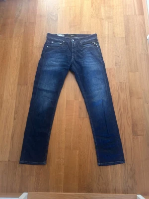 Mörkblå Replay jeans Grover - Säljer ett par mörkblå jeans från Replay, modell Grover. Jeansen har raka ben, klassisk femficksdesign och snygga slitningar framtill. Materialet är mjukt denim med en schysst tvätt och detaljerade sömmar. Perfekta för dig som gillar stilrena och bekväma jeans.