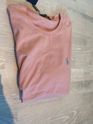 Rosa Ralph Lauren T-shirt  - Tja! Säljer en helt ny rosa Ralph Lauren T-shirt i storlek L.  Priset kan diskuteras och skickar inom 24 Tim😊💨