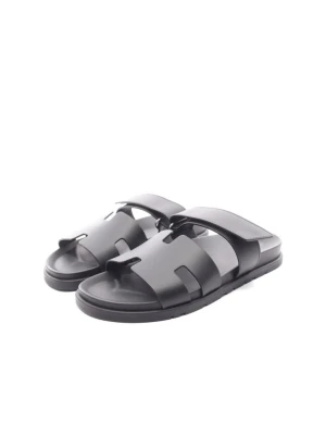 Svarta sandaler från Scholl - Stilrena svarta sandaler från Scholl med breda remmar i syntetmaterial och öppen tå. Sval design med klassisk slip-in-modell och mönstrad sula för extra grepp. Perfekta för sommaren och enkla att matcha med olika outfits.