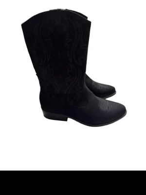 Svarta cowboy boots med broderi - Snygga svarta cowboy boots med dekorativa broderier längs skaftet och på tån. Klassisk spetsig tå och låg klack. Tillverkade i mockaimitation som ger en cool och stilren look. Perfekta för dig som vill addera western-vibe till outfiten.