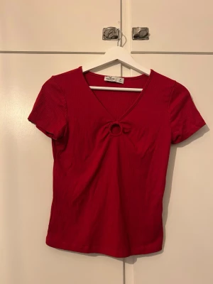 Röd topp - En röd topp i storlek M från Hollister. Mjuk, skönt och stretchigt material. Den är figurnära utan att sitta åt. Är något cropped/kortare.