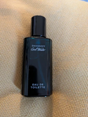 Davidoff Cool Water - Fräsch parfym från Davidoff, Cool Water. Flaskan är rektangulär i mörkblått glas med svart lock. Doften är klassiskt fräsch och passar perfekt för dig som gillar en sval och maskulin känsla. Endast använd lite, se sista bild hur mycket som är kvar. 