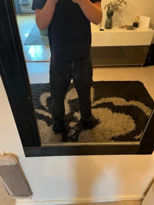 Svarta raka jeans - Säljer ett par svarta jeans med rak passform och klassisk femficksdesign. Jeansen har normal midja och dragkedja med knapp framtill. Perfekta för en avslappnad och stilren look.