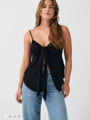 Svart linnetopp med knyt framtill - Jättefint linne med knyte framtill från Gina tricot. Materialet är väldigt skönt och luftigt, perfekt till varma sommardagar! Knappt använd och är i storlek S💗