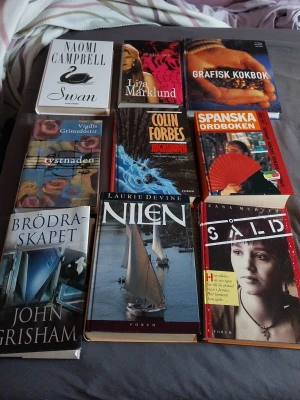 Bokpaket: Skönlitteratur & Ordbok - Säljer ett blandat bokpaket med skönlitteratur och en spansk ordbok. Innehåller titlar av Naomi Campbell, Liza Marklund, John Grisham, Vigdis Grimsdottir, Colin Forbes, Laurie Devine och fler. Böckerna har olika omslag i färger som vitt, blått, rött och beige. Perfekt för dig som gillar att läsa olika genrer