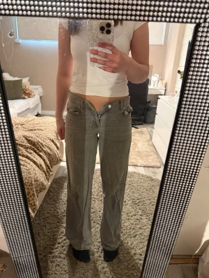 Grå raka jeans med låg midja - Säljer ett par grå jeans med rak passform och låg midja. Jeansen  stängs med knapp och dragkedja. Säljs pga: för små. Passar bra för mig som är 170!