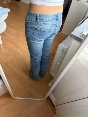 Blå bootcut jeans med låg midja - Skit snygga Bootcut jeans i klassisk denim med låg midja och fem fickor. Jeansen har gylf med dragkedja och knapp. Säljer då de tyvärr blivit för små för mig 