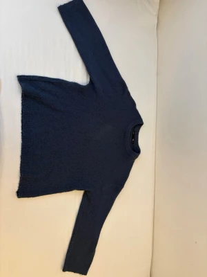 MörkBlå stickad tröja från Lager 157 S men passar som storlek M - Mysig blå stickad tröja från Lager 157 med rund halsringning och ribbstickade muddar. Tröjan har en enkel och stilren design, perfekt att matcha med jeans eller kjol. Materialet känns mjukt och skönt mot huden. Och den ser mörkare ut eftersom ljuset gjorde det till lite marin blå aktit men kan skicka privat en bättre video/bild.