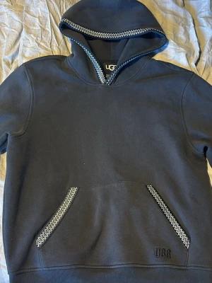 Ugg hoodie  - Snygg svart hoodie från UGG med coola vita zigzag-detaljer längs huva och fickor. Klassisk känguruficka framtill och broderad UGG-logga nedtill. Nypris 1300kr. väldigt bra skick. Pris går att diskutera 