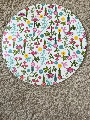 Rund mat underlag med färgglatt blommönster - Ett runt underlag i vitt med färgglatt blommönster i rosa, gult, blått och grönt. Brickan har en lekfull och modern design med olika sorters blommor och blad. Perfekt som serveringsbricka eller dekoration i hemmet.
