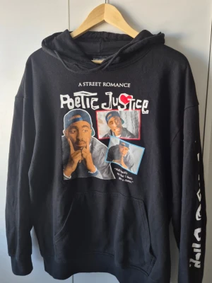 2pac poetic Justice hoodie - Säljer en svart vintage hoodie med tryck från Poetic Justice och texten 'A Street Romance' på bröstet. Hoodien har stor ficka framtill, huva och tryck på ena ärmen. Materialet känns mjukt och bekvämt, perfekt för en avslappnad streetwear-look. Storlek L men passar M