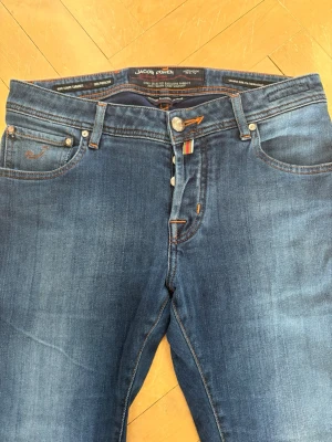 Jacob Cohën Jeans W31 - Hej! Säljer ett par Jacob Cohën 622 i storlek W31-L32 (105 cm långa). Slim passform.                                                Blå washed jeans i mycket bra skick (nästan som nya). Tillverkade i Italien.                                                   Skick: 8/10  Nypris: ca 5200kr                                   Hör av dig vid frågor eller intresse!