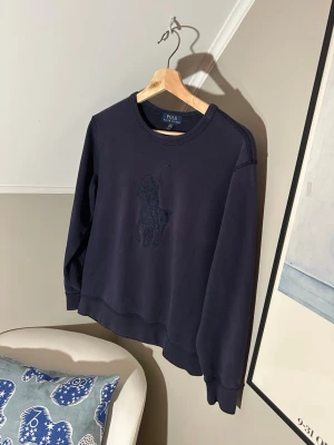 Marin blå Polo Ralph Lauren tröja - En riktigt snygg sweatshirt från Polo Ralph Lauren     Skick: 8/10                                                              Färg: Marin blå                                                                          Storlek: L 14-16 vilket motsvarar XS-S.                         Har ni några frågor eller prisförslag är det bara att skicka