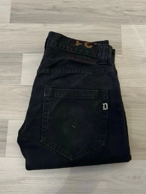 Dondup jeans - Svarta jeans från Dondup med klassisk femficksdesign och metall-D på bakfickan. Modellen har rak passform och normal midja, tillverkade i slitstarkt bomullsmaterial. Perfekt för dig som gillar stilrena och tidlösa jeans med snygga detaljer. Storlek: W31 L32