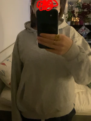 Ljusgrå basic hoodie med huva - Storlek 158/164!! En enkel och stilren ljusgrå hoodie med huva och dragsko. Hoodien har ribbade muddar vid ärmslut och nederkant samt en avslappnad passform. Perfekt för chill dagar eller när du vill ha något bekvämt och neutralt. Materialet känns mjukt och skönt mot huden.