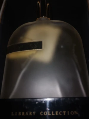 Amouage Library Collection parfym - Lyxig parfym från Amouage Library Collection i en elegant frostad glasflaska med gulddetaljer. Flaskan har en rundad form och levereras i en exklusiv vit förpackning med svart band och guldfärgad knapp. Perfekt för dig som gillar exklusiva dofter.