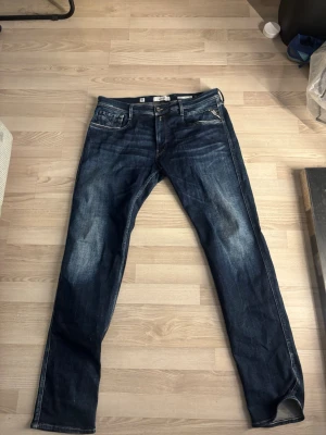 Mörkblå replay jeans med en skön wash  - Snygga mörkblå jeans med raka ben och klassisk femficksmodell. Jeansen har kontrastsömmar och slitningar framtill för en cool look. Passar perfekt till en avslappnad stil och är tillverkade i ett robust denimtyg. 
