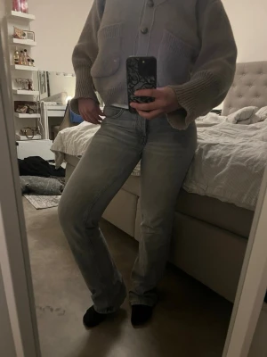 Ljusblå raka jeans - Säljer ett par ljusblå jeans med rak passform och klassisk femficksdesign. Jeansen har normal midja och subtila slitningar för en avslappnad look. Perfekta till vardagsstilen och passar till det mesta. Materialet är denim i bomull.