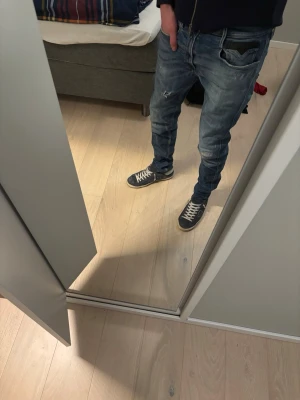 Replay Anbass blå jeans herr - Säljer ett par snygga Replay Anbass jeans i tvättad blå denim. Modellen har smal passform, klassiska fem fickor och coola slitningar på benen. Perfekta för dig som gillar en avslappnad men trendig stil.
