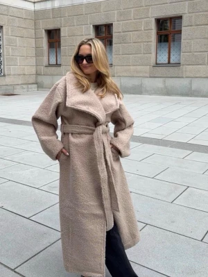 Beige teddy-kappa med knytskärp - Snygg beige teddy-kappa med oversized passform och bred krage. Kappan har ett knytskärp i midjan och stora slag, vilket ger en trendig och avslappnad look. Perfekt för dig som gillar stilrena och mysiga ytterplagg. Materialet är mjukt och fluffigt. Slutsåld!!!!