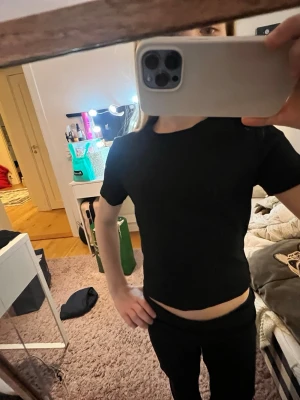 Svart basic t-shirt från H&M - En svart basic t-shirt från H&M med klassisk rund hals och korta ärmar. Tillverkad i mjuk bomull som känns skön mot huden. Enkel och clean design som är lätt att styla till olika looks.