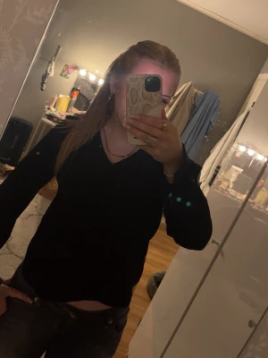 Svart v-ringad långärmad blus  - En svart långärmad blus med v-ringning. Enkel och stilren design som passar till många olika outfits. Blusen har en normal passform och är perfekt för dig som gillar klassiska basplagg.