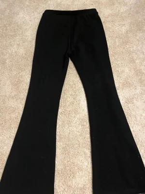 Svarta bootcut leggings Kappahl - Säljer ett par svarta leggings från Kappahl i storlek 158. De har bootcut-modell med utsvängda ben och resår i midjan. Perfekta till en avslappnad och trendig look. Materialet är mjukt och stretchigt för extra komfort. Byxorna är varma och väldigt mjuka på insidam.