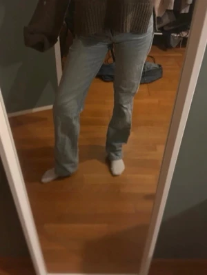 Ljusblå bootcut jeans - Säljer ett par ljusblå bootcut jeans med klassisk femficksdesign och hög midja. Jeansen har en avslappnad passform och är tillverkade i denim. Perfekta för en trendig och bekväm look.