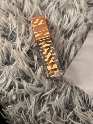 Maybelline läppstift Blush - Snyggt läppstift från Maybelline i färgen Blush. Hylsan har en modern design med guld- och svartmönster. Perfekt för dig som vill ha en mjuk, naturlig ton på läpparna och gillar trendiga förpackningar.