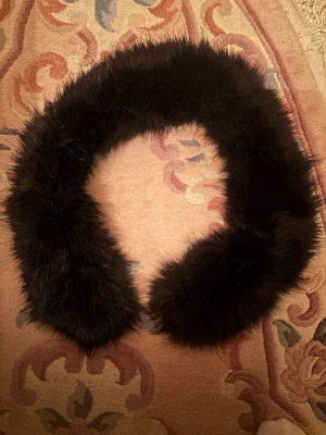 Svart fuskpäls-sjal - Mysig svart sjal i fuskpäls med fluffig och lyxig känsla. Perfekt att slänga över axlarna för en extra touch till din outfit. Rund form som enkelt läggs runt halsen.