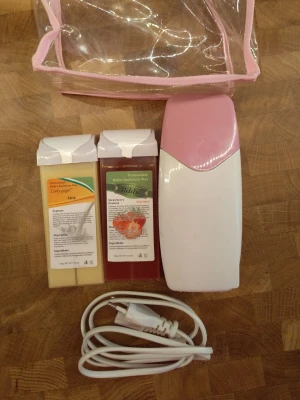 Vaxvärmare med två vaxpatroner - Säljer ett kit med vaxvärmare i vitt och rosa plast, två vaxpatroner (mjölk och jordgubb) samt strömkabel. Perfekt för enkel hårborttagning hemma. Allt kommer i en genomskinlig necessär med rosa kant. Vaxremsor kan med fördel göras av gamla slitna lakan.