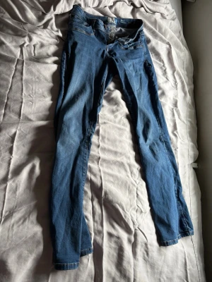 Blå bootcut/lowv waist jeans från l.t.b Molly - Säljer ett par blå skinny jeans från l.t.b, modellen Molly med low rise bootcut. Jeansen har klassisk femficksdesign, dragkedja och knapp framtill samt snygga kontrastsömmar. Perfekta för dig som gillar en tajt passform och låg midja.