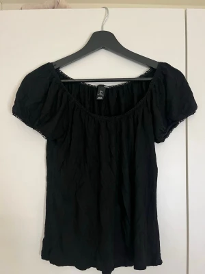 Svart offshoulder topp från H&M - Säljer en svart offshoulder topp från H&M med puffiga korta ärmar 